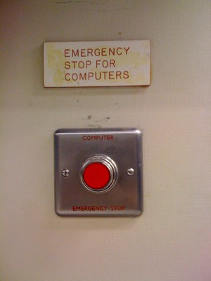 Red push button on the wall labeled, Emergency Stop for Computers