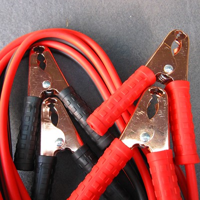 Red Jump Start Cables with red handles and black handles, on a Table
