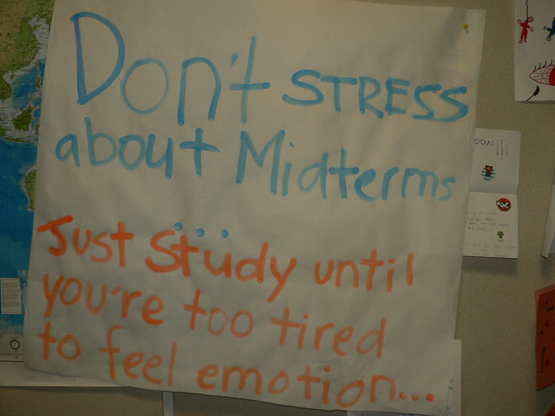 Large white poster on a bulletin board with the message: Don't stress about midterms...Just study until you're too tired to feel emotion...