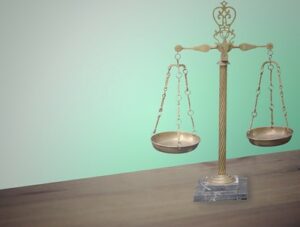 Gold colored scales of justice sitting on a wooden table